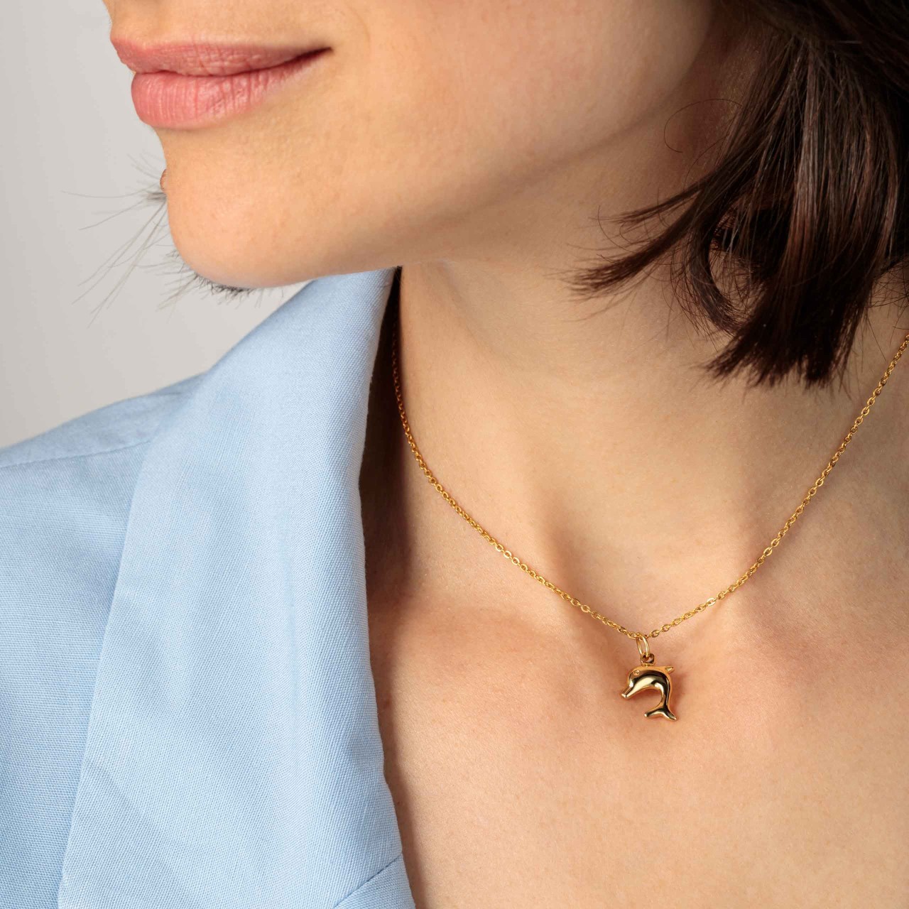 Позлатен медальон с красиво усмихнат делфин